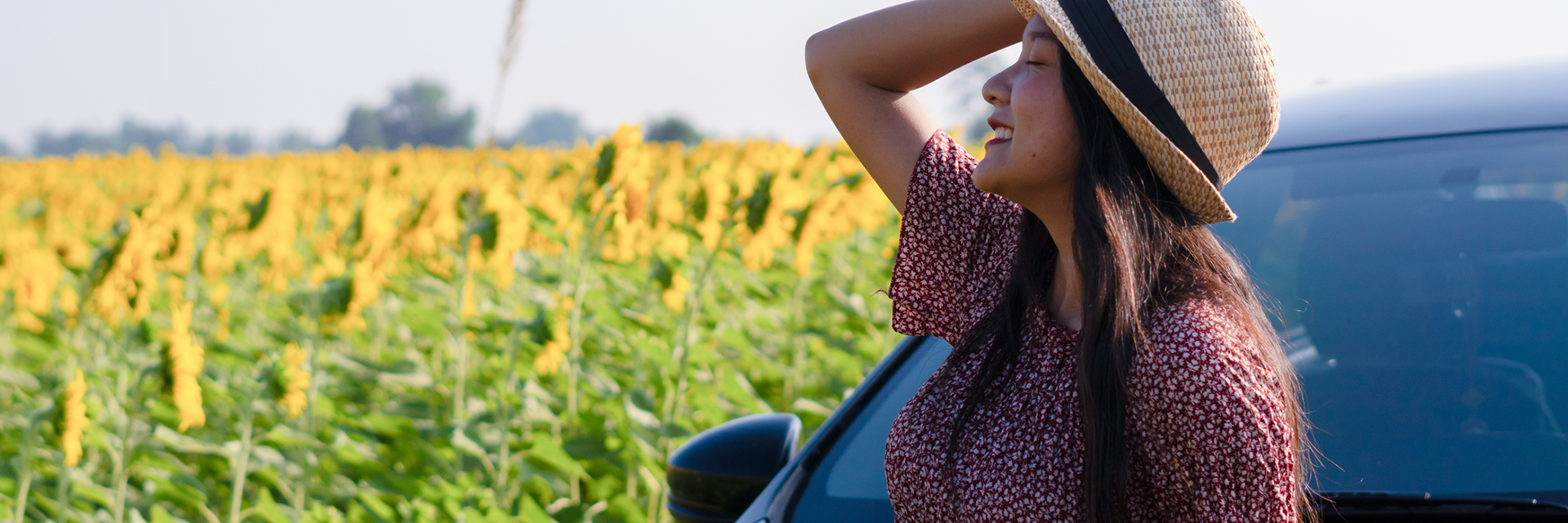 blue car driving through fall leaves